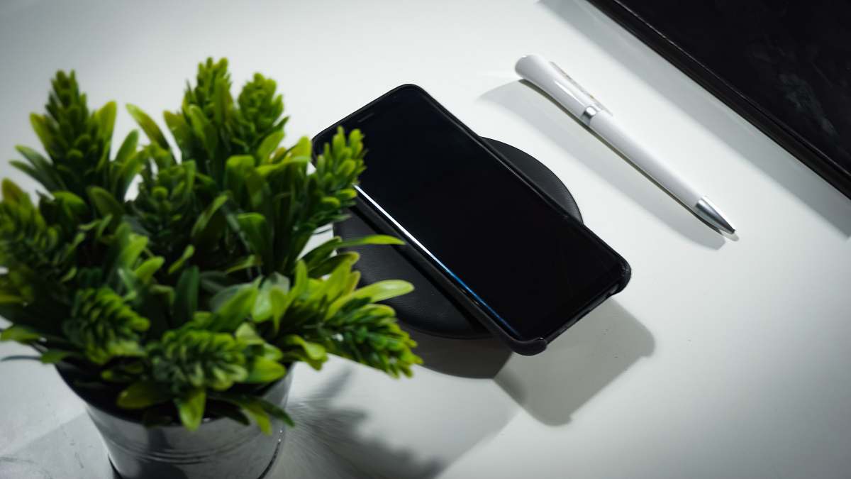 cell phone smartphone place on wireless charger on table electronics